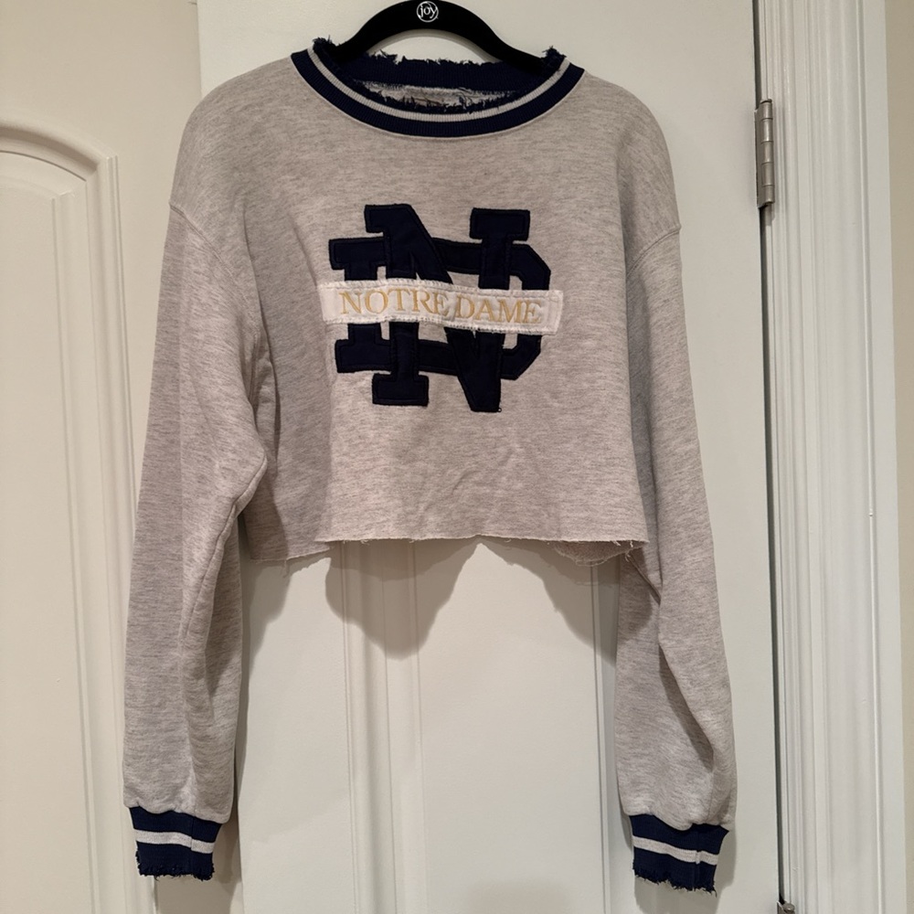Gray cropped crew neck sweater with black hashtag and navy blue trim
